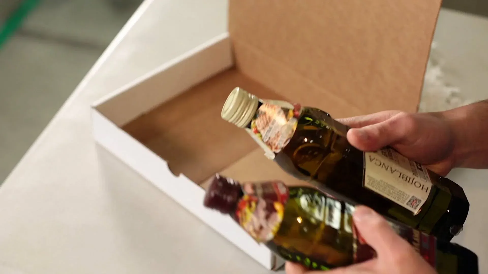 Person packing olive oil in box
