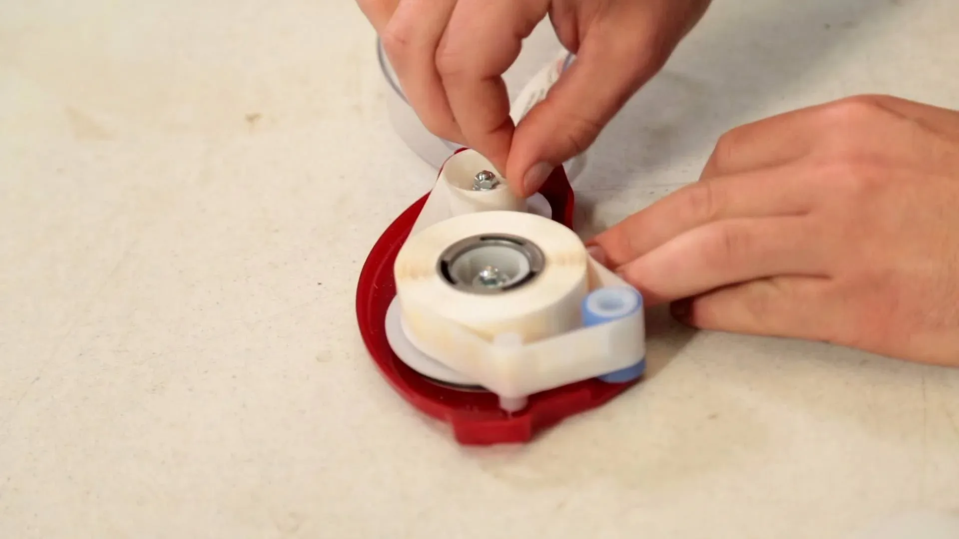 Hands assembling a tape dispenser
